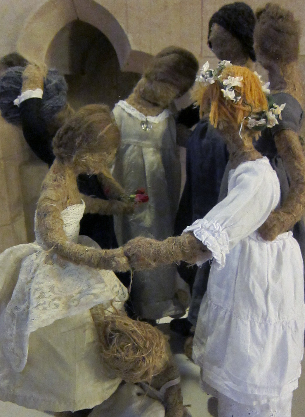 A group of dolls dance around in a circle